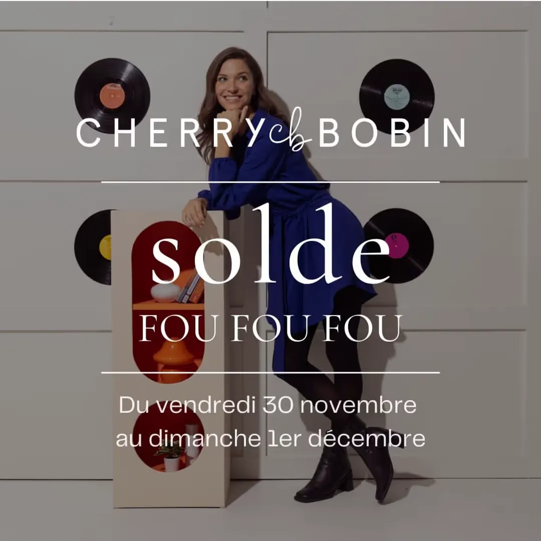 Femme souriante en robe bleue appuyée sur une étagère blanche avec vinyles noirs accrochés au mur, publicité pour la vente fou fou fou du 30 novembre au 1er décembre.