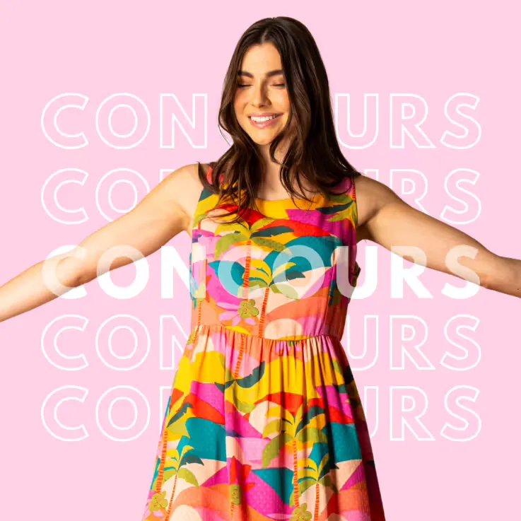 Jeune femme souriante portant une robe colorée à motifs floraux, bras écartés devant un fond rose avec le mot « concours » répété en blanc.